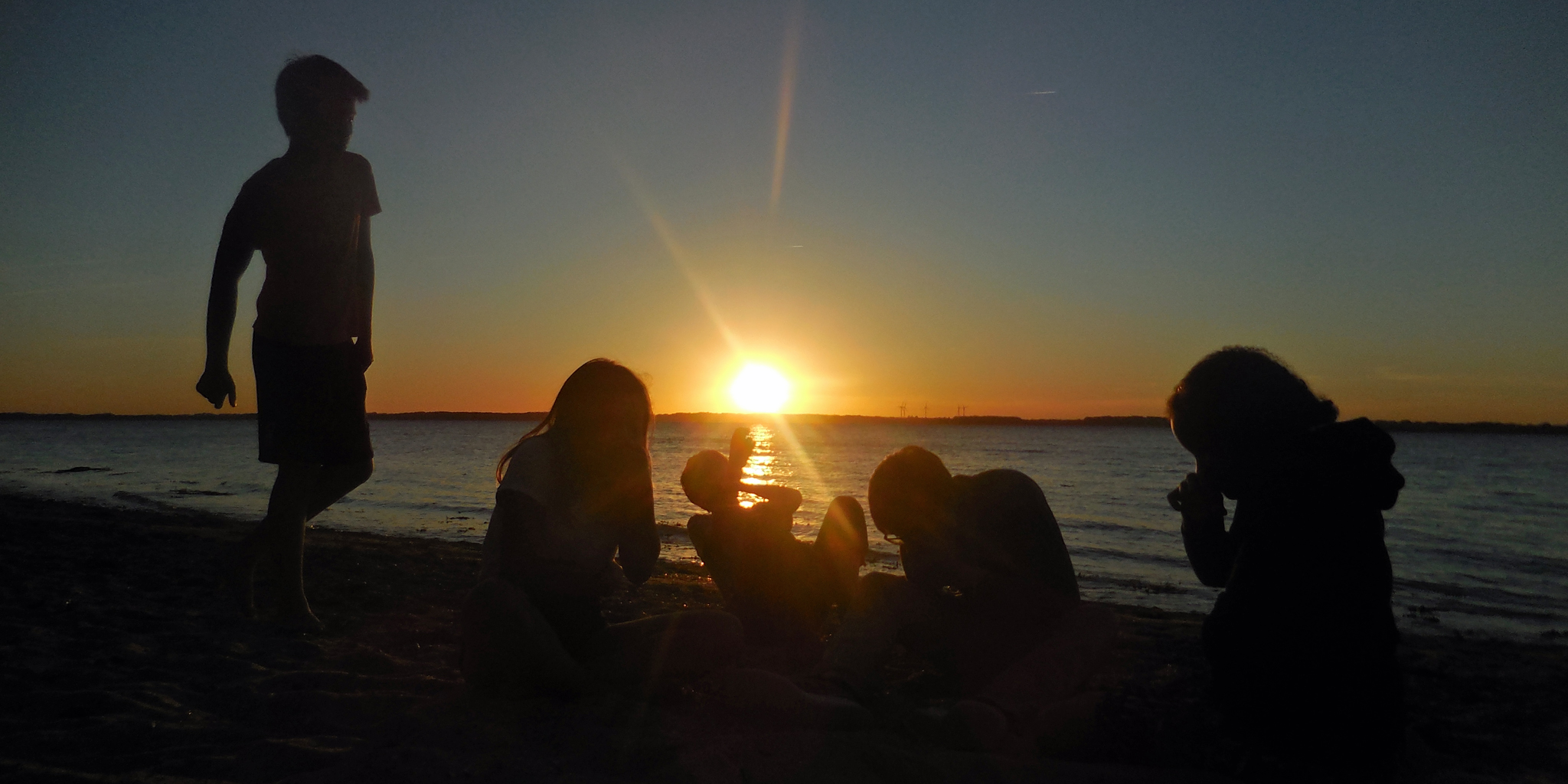 Jugendliche am Strand im Sonnenuntergang